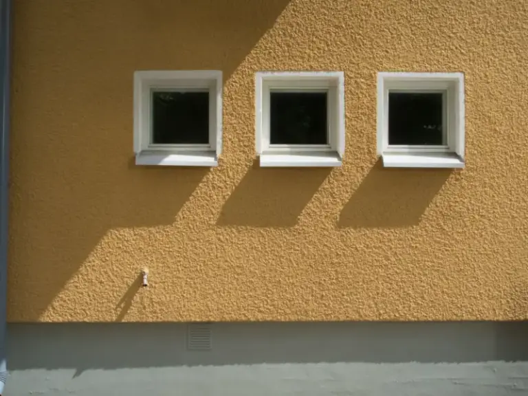Gevel met structuurpleister en witte raamkaders